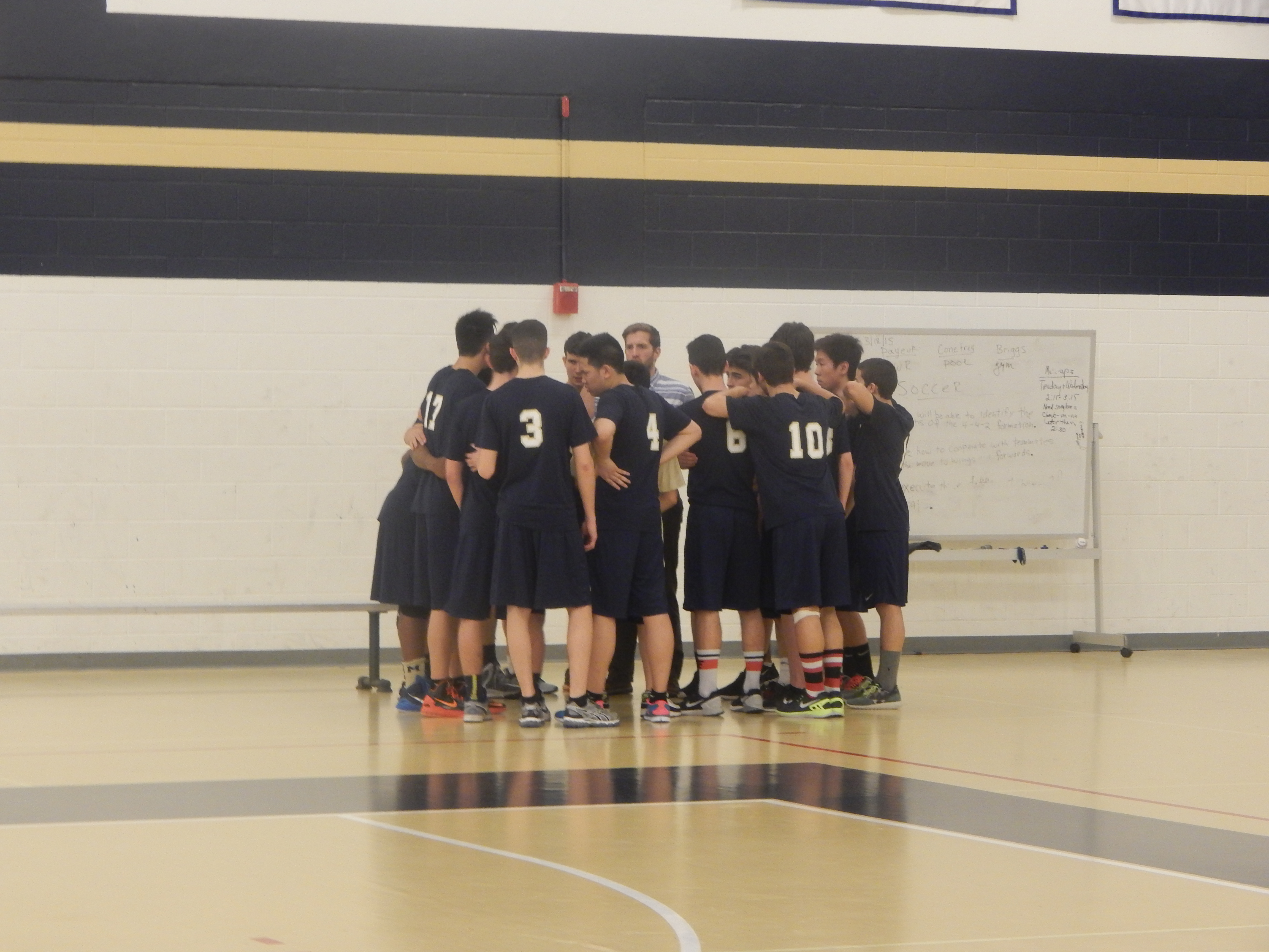 The team huddles before the start of the game. Photo by Meagan Sullivan.