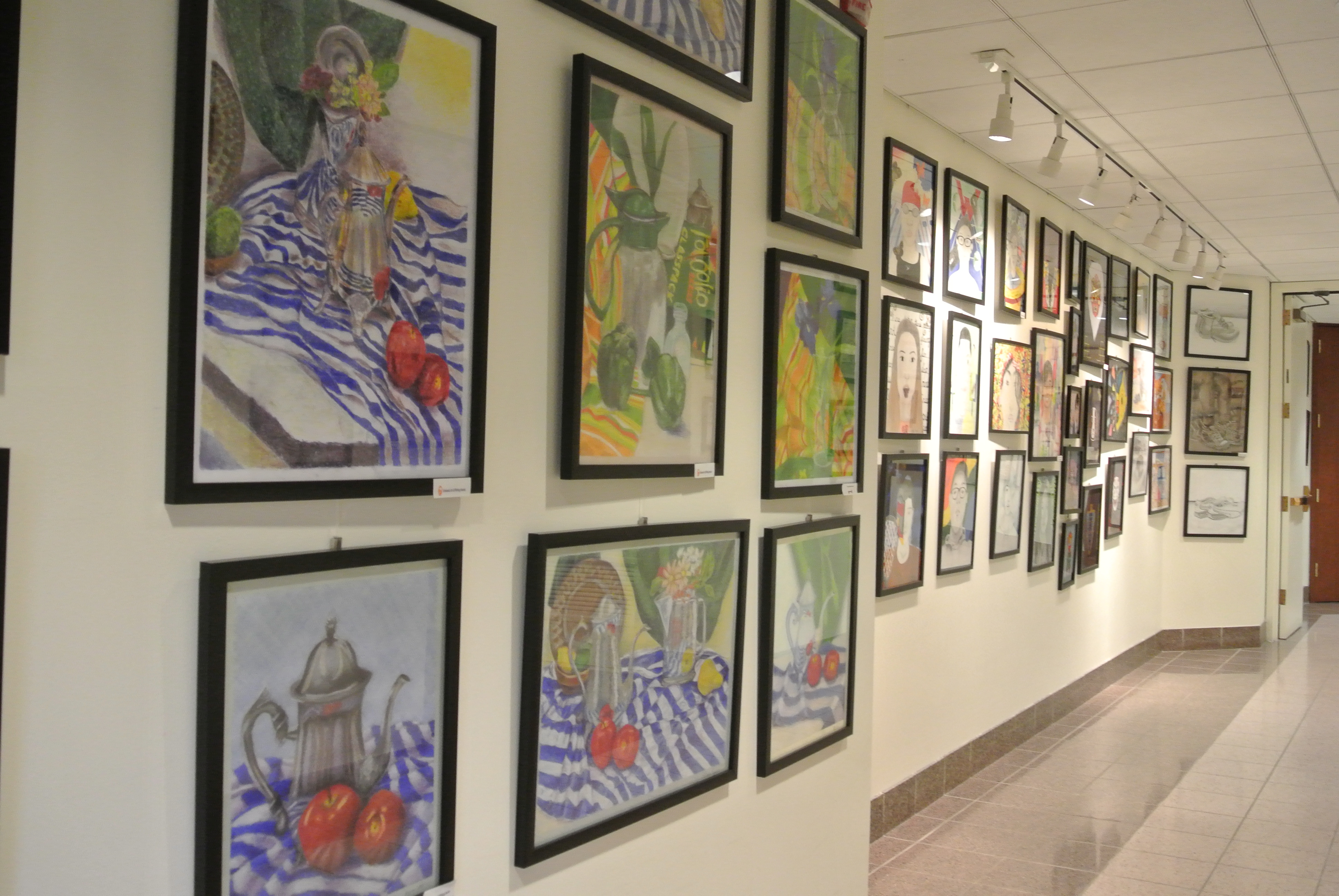 A hallway of students are work presented at the gallery. 