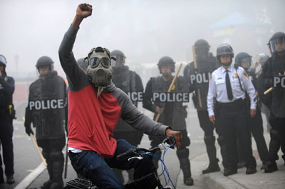 A protester rides his bike in front of a police line at North and Pennsylvania Avenues on Monday, April 27, 2015, in Baltimore. (Algerina Perna/Baltimore Sun/TNS)