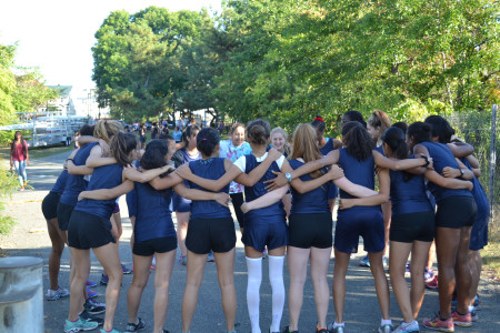 The girls cross country team in a huddle before their meet against Somerville. Photo by Jesaias Benitez. 