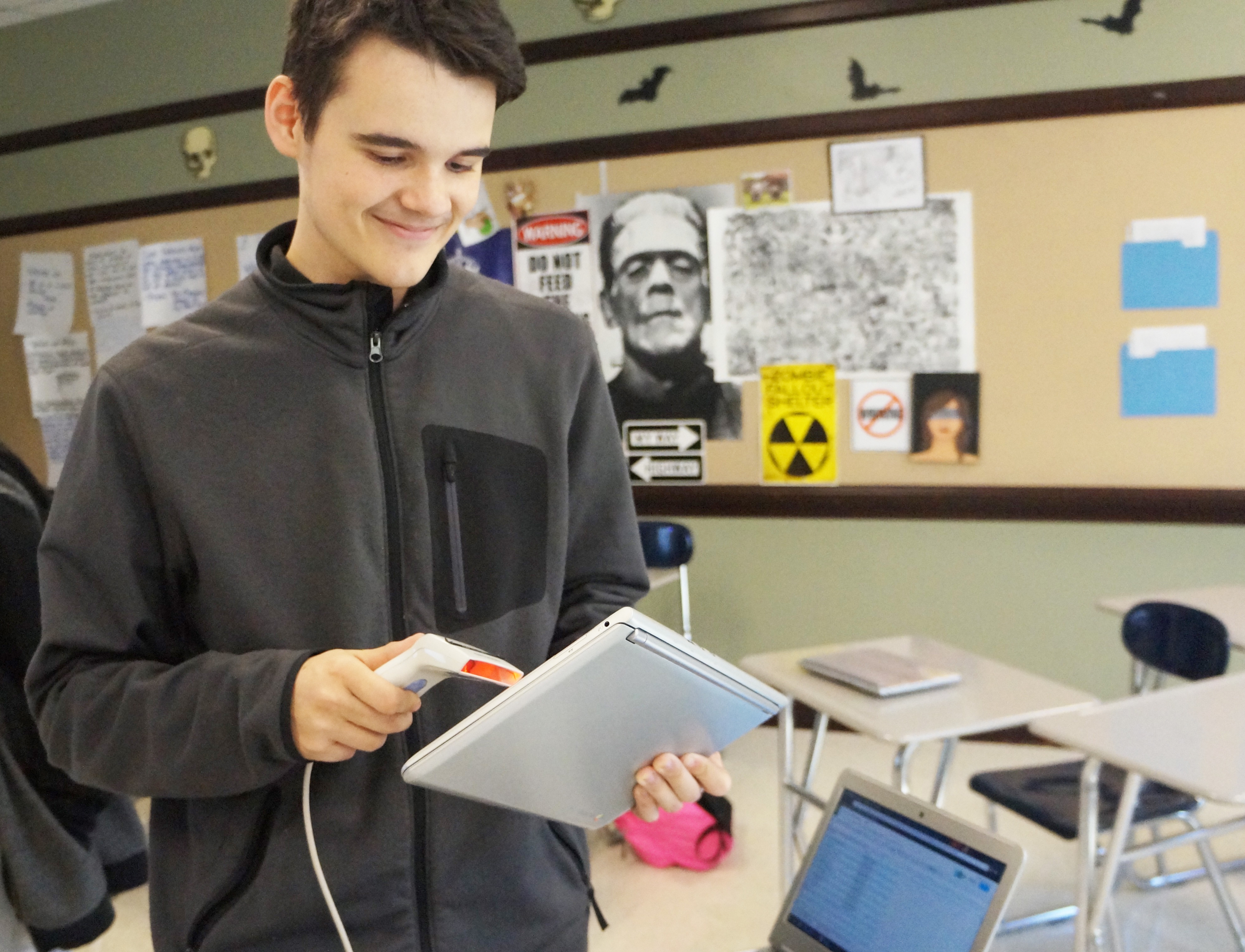 Senior Blue & Gold member Jasper Haag scanning a Chromebook. Photo by Samuel Martinez.