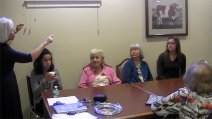 Seniors Cynthia Salguero and Laura Suarez with residents from the center listening to the activities director's lesson. Photo by Ymanika Nicolas.
