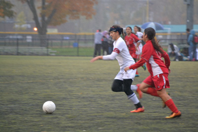 Senior Alex Lombardi taking the ball towards the net. Photo by