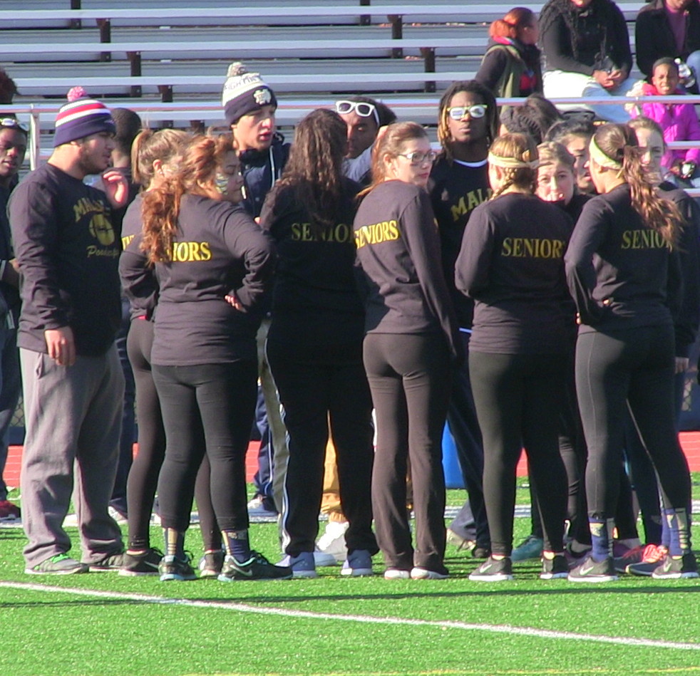 The senior powderpuff team in a huddle during the game. Photo by Tenzin Dorjee.