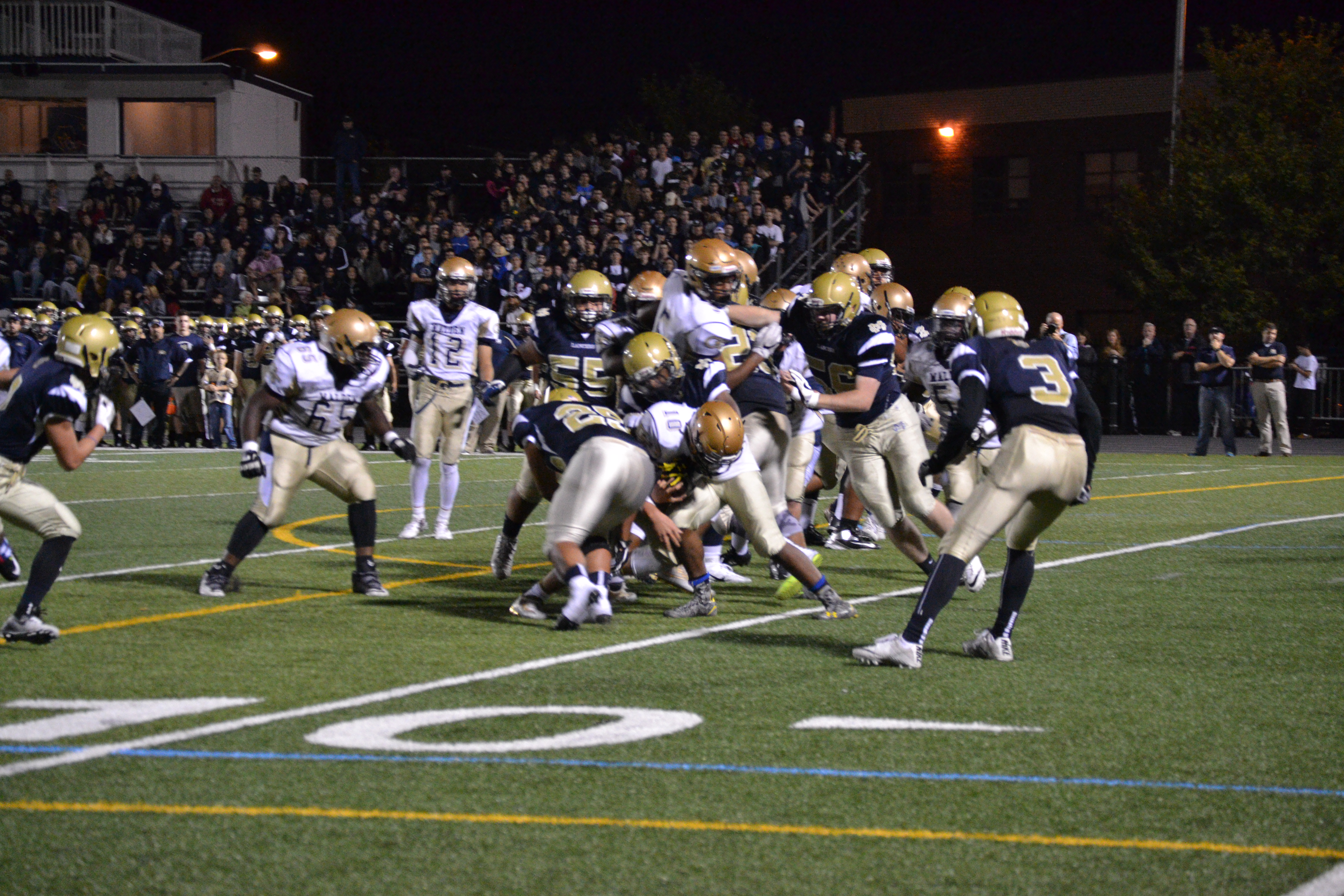 Quarterback and captain, junior Jared Martino fighting for extra yards as multiple Lancer defenders attempt a tackle