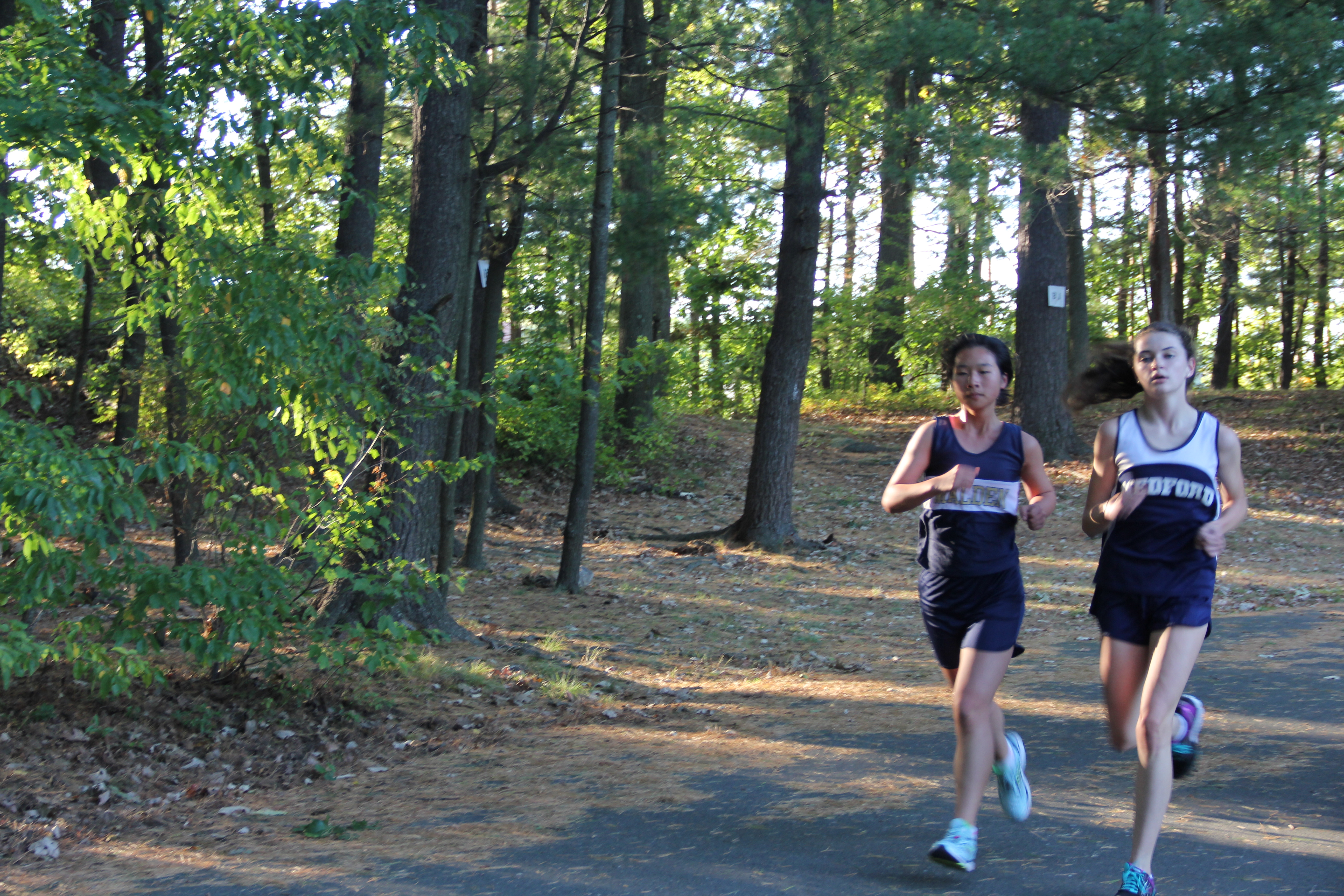 Junior Yongting Chen runs beside a Medford runner. Photo taken by Sara Zakaria. 