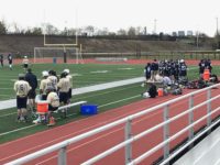 Members of Malden and Winthrop's lacrosse team on the sidelines.