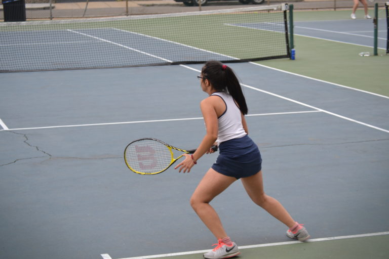 Nikita Puri runs back to the serving line to return a serve