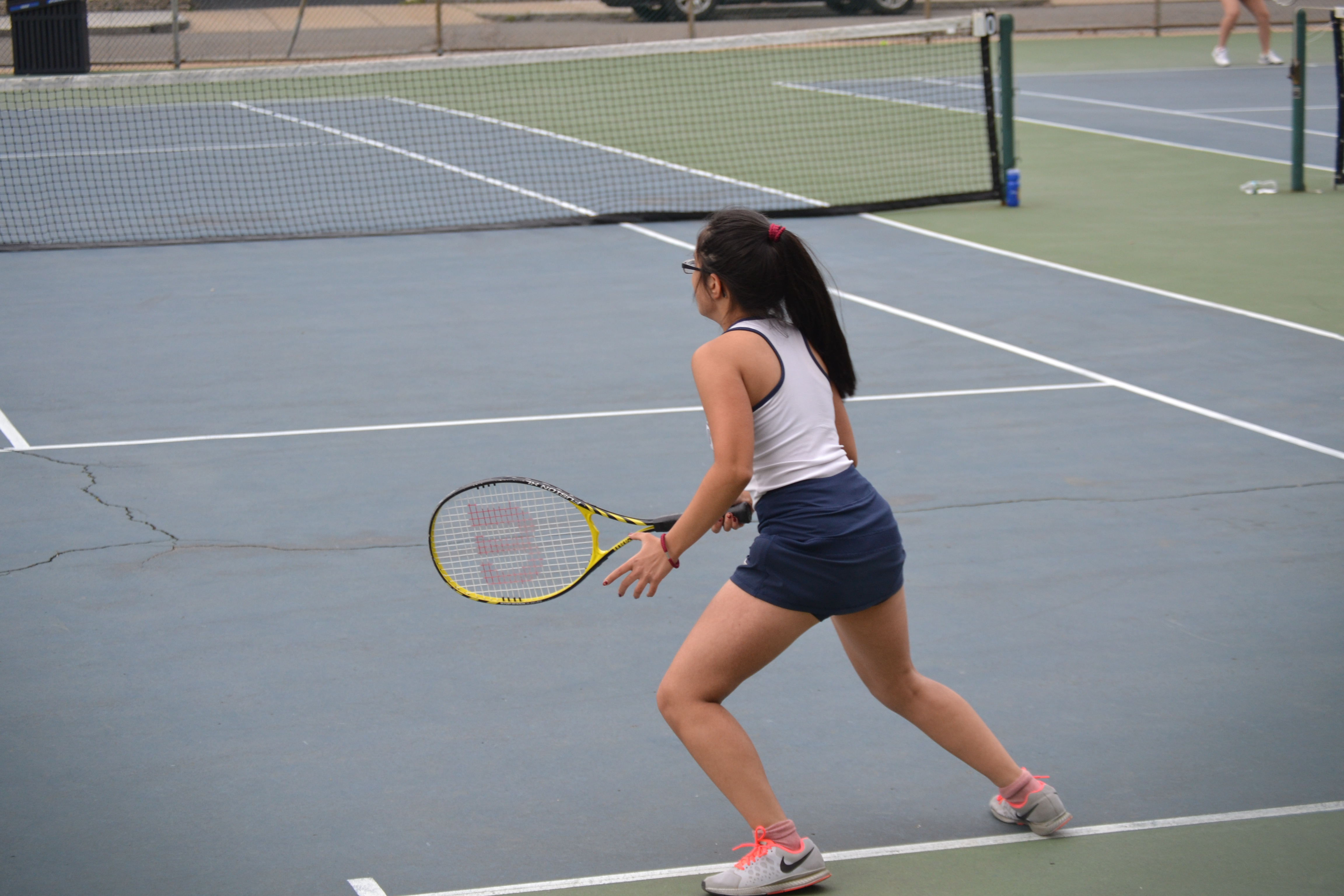 Nikita Puri runs back to the serving line to return a serve